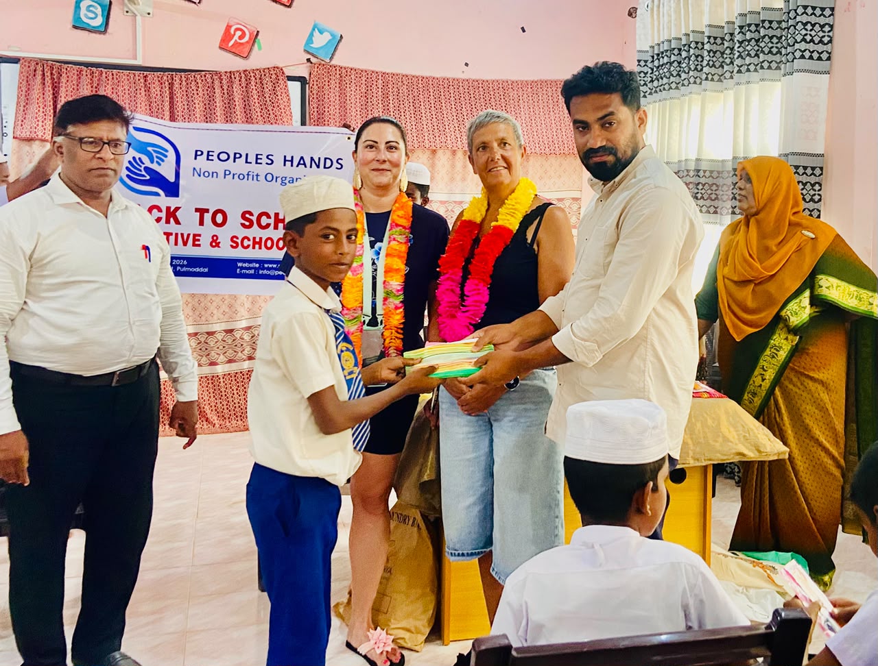 Amandine from France giving school kit to a student with People's Hands Organization coordinator, Kuchchaveli, Trincomalee